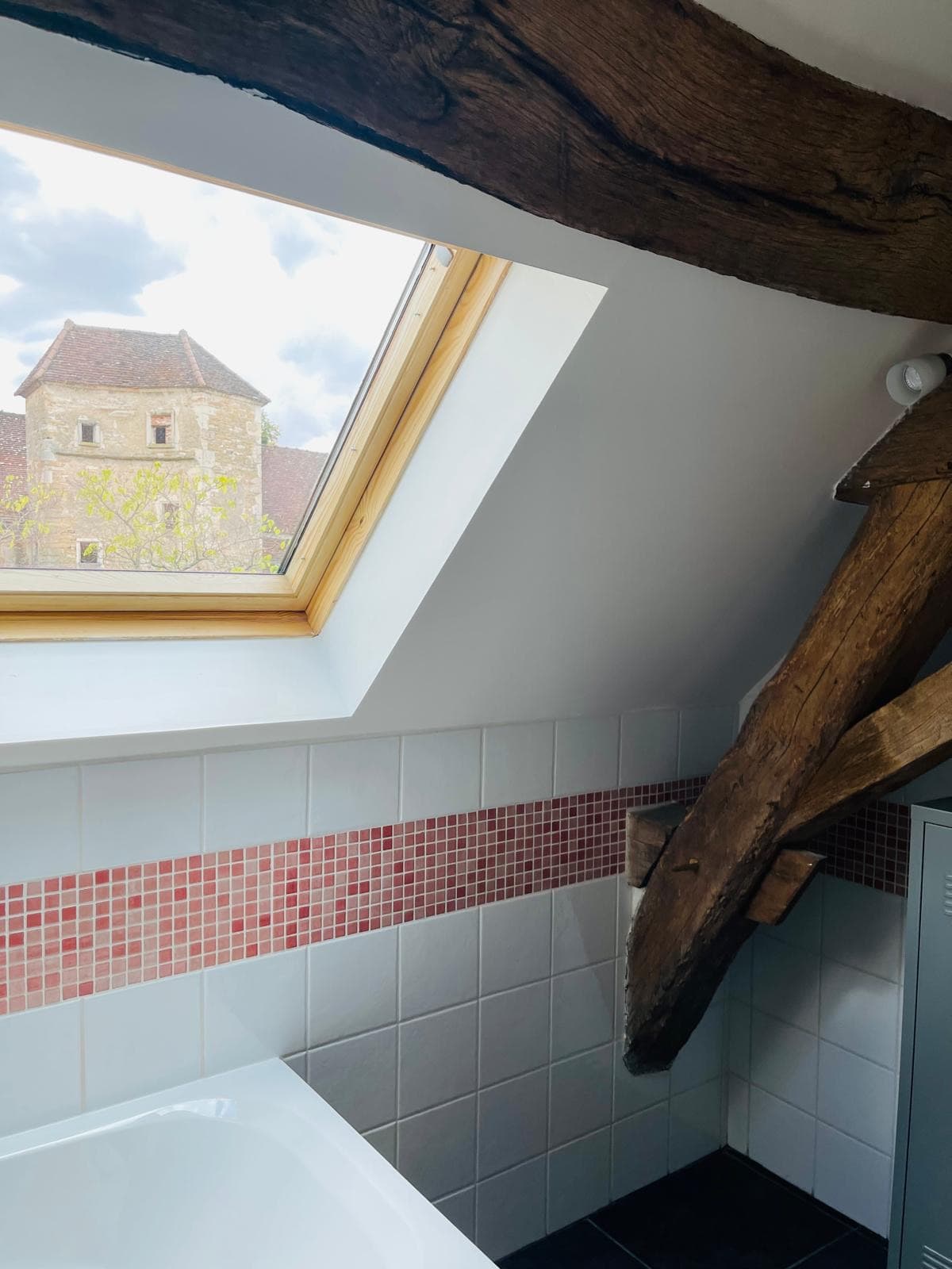 Der Turm des Schlosses von Étrigny, gesehen durch das Dachfenster des Badezimmers, unter den hundertjährigen Balken
