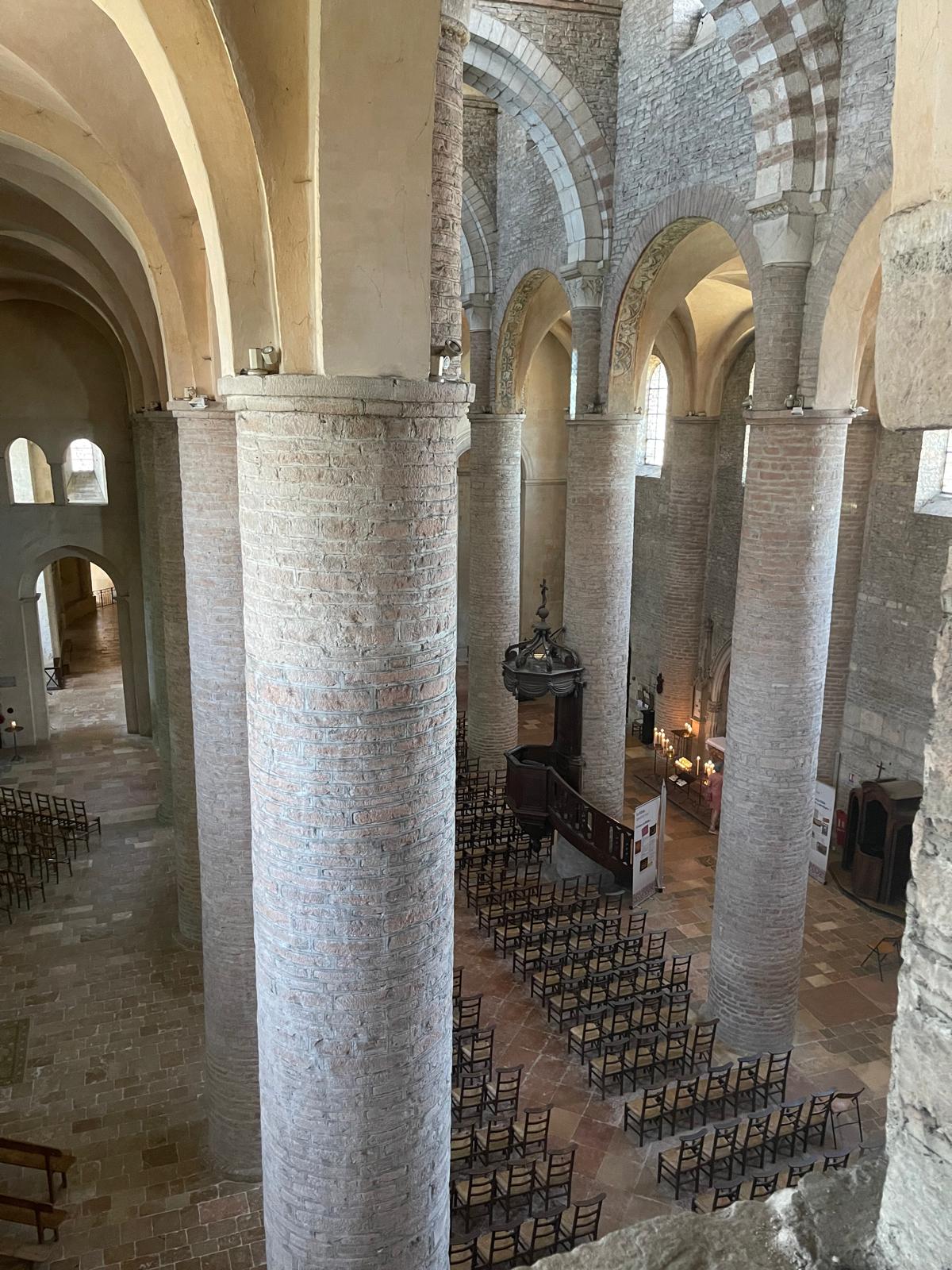 La nef romane et ses hautes colonnes de pierre rose